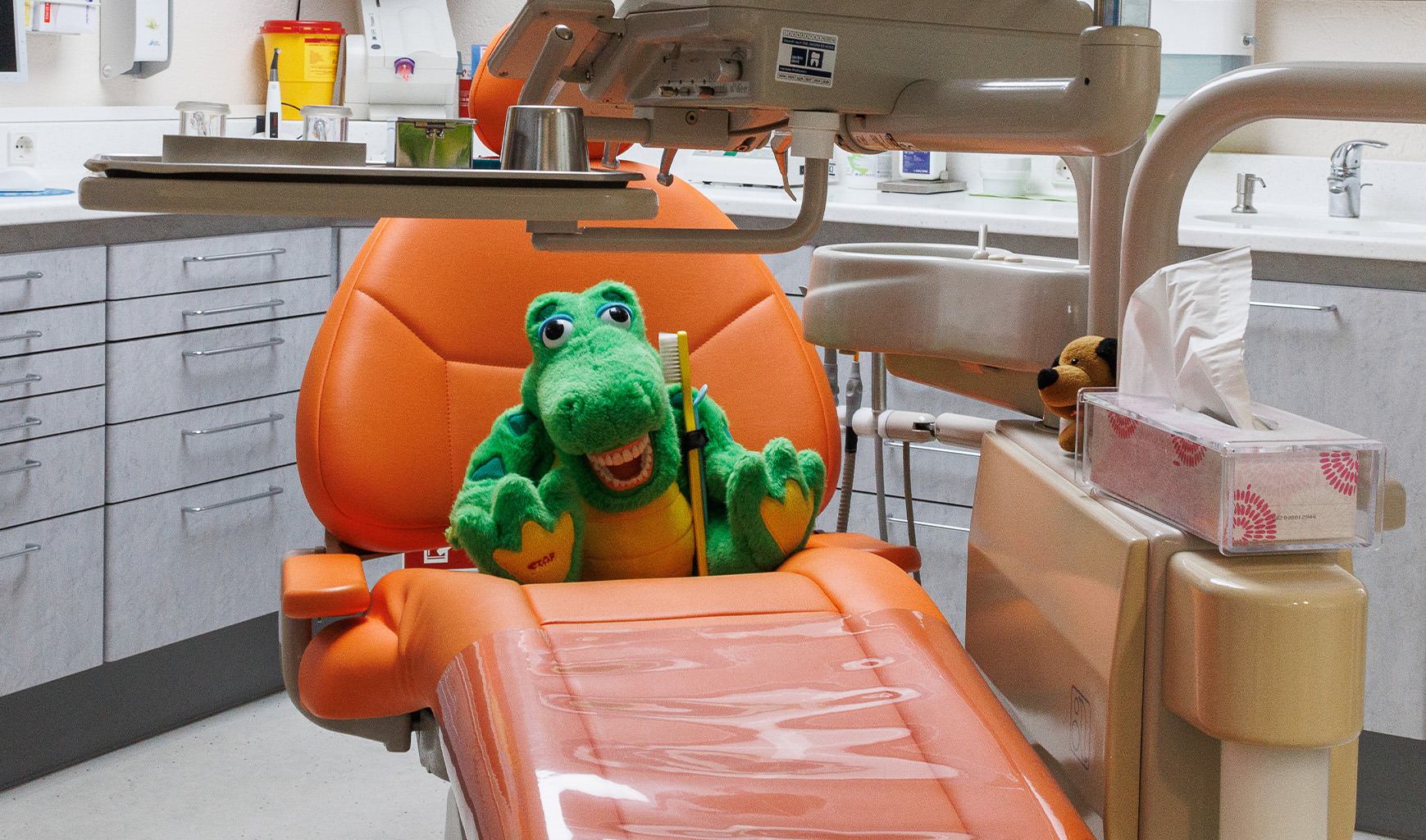 Korkodil-Stofftier sitzt auf Patientenstuhl